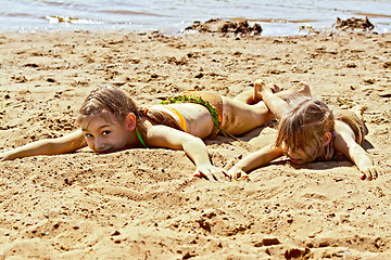 Image showing Two girls on sand by the river