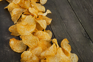 Image showing potato chips on a wooden background