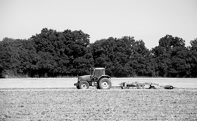 Image showing Tractor and harrow cultivating the soil