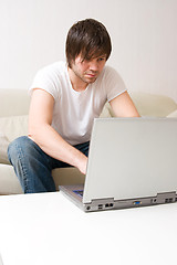 Image showing young man home with laptop