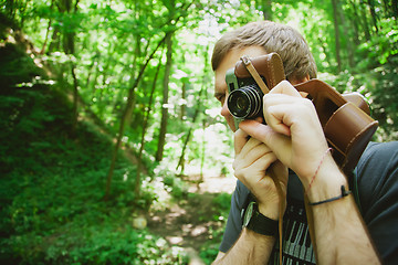 Image showing Closeup of young hipster man with digital camera outdoors.