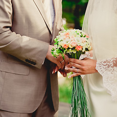 Image showing mans hand putting a wedding ring on the brides finger