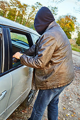 Image showing Hooligan breaking into car