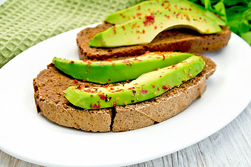 Image showing Sandwich with avocado and pepper on light board