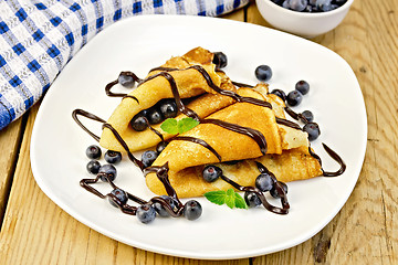 Image showing Pancakes with blueberries and chocolate on board