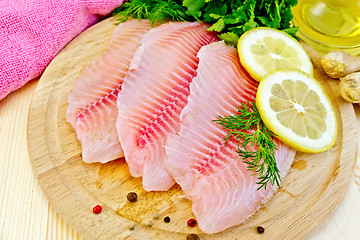 Image showing Tilapia with oil and lemon on light board