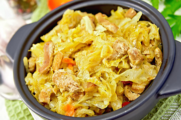 Image showing Cabbage stew with meat in black brazier on green napkin