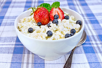 Image showing Curd in bowl with strawberries and blueberries on tablecloth