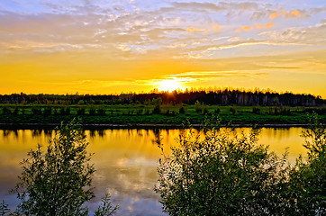 Image showing Sunset on river with trees and bushes