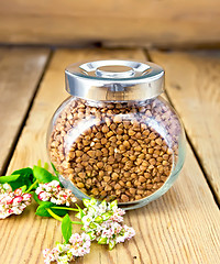 Image showing Buckwheat in glass jar and flower on board