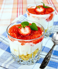 Image showing Dessert milk with strawberry and flakes in glass on blue napkin