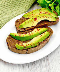 Image showing Sandwich with avocado and parsley on light board