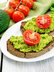 Image showing Sandwich with guacamole and tomato on light board