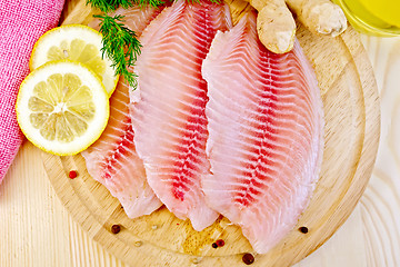 Image showing Tilapia with parsley and lemon on light board