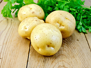 Image showing Potatoes yellow with parsley on wooden board