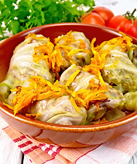 Image showing Cabbage stuffed and carrots in ceramic pan on board