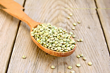 Image showing Lentils green in wooden spoon on board