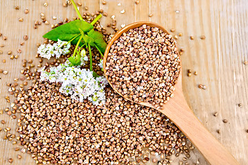 Image showing Buckwheat on board with flower and wooden spoon