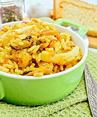 Image showing Pilaf with seafood in green pot on napkin