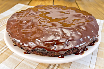 Image showing Pie chocolate with icing and napkin on board