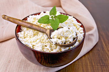 Image showing Curd in wooden bowl with spoon on napkin and board