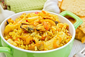 Image showing Pilaf with seafood and bread on board