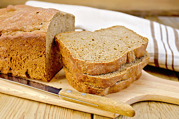 Image showing Rye homemade bread stacked on board with napkin