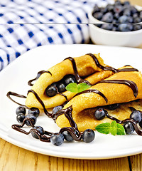 Image showing Pancakes with blueberries and chocolate on wooden board