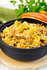 Image showing Cabbage stew with meat in black roaster on board