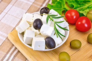 Image showing Feta with olives in bowl on fabric and board