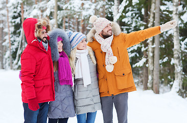 Image showing group of smiling men and women in winter forest