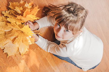 Image showing The girl with maple leaves