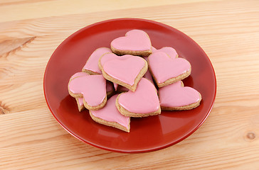 Image showing Red plate stacked high with iced heart-shaped cookies