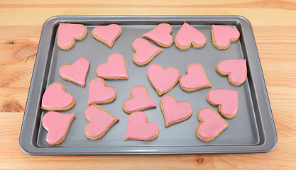 Image showing Array of heart-shaped cookies with pink frosting