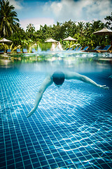 Image showing Man floats underwater in pool