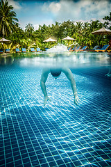 Image showing Man floats underwater in pool