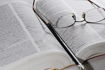 Image showing open book with glasses and pencil