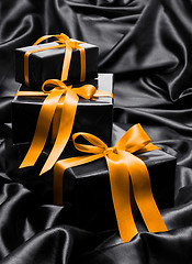 Image showing Black gift boxe with yellow satin ribbons and bows