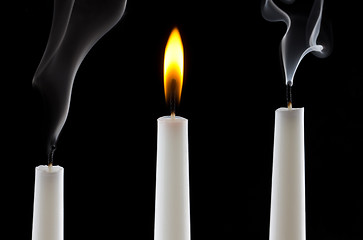 Image showing burning candle with extinguished candles