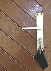 Image showing The door latch of a wooden door with bunch of keys