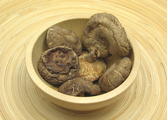 Image showing Wooden bowl with shiitake on bamboo plate