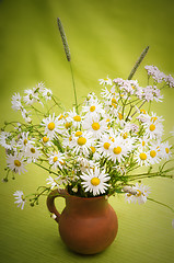 Image showing Bouquet of wild flowers in a clay pot, close-up  