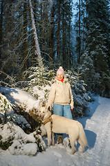 Image showing Woman with dog in winter forest on a walk