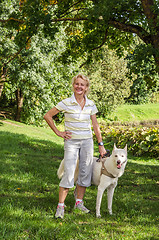 Image showing Woman with a dog on a walk in the park