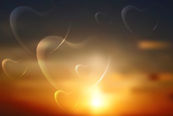 Image showing Shiny hearts on sunset sky background