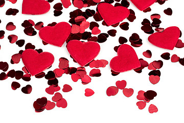 Image showing Red hearts confetti and fabric heart on white background