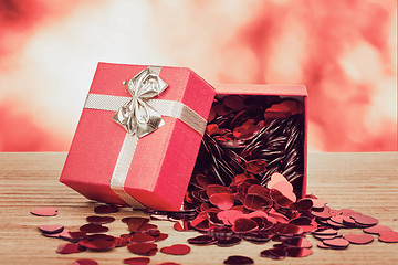 Image showing Red hearts confetti on wooden background and bokeh