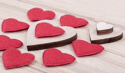 Image showing valentine's fabric and wooden hearts on a wooden background