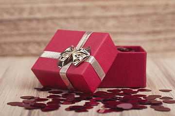 Image showing Red hearts confetti on wooden background