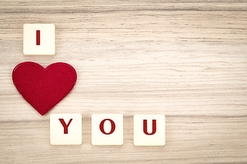 Image showing valentine's hearts on a wooden background and tex i love you